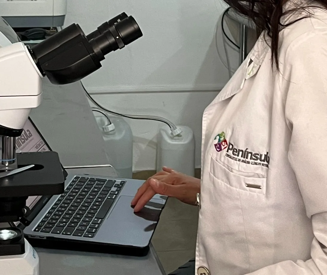 Especialista de Península en el microscopio registrando resultados